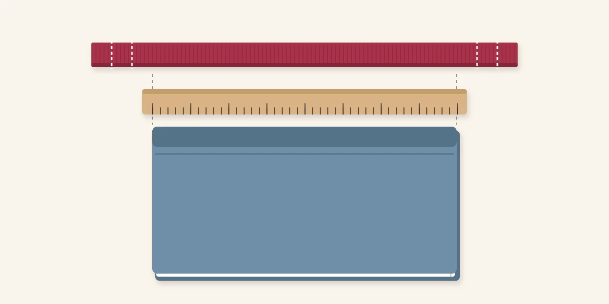 Ribbon laid beside a book and ruler to measure the bookmark length, with fold positions marked