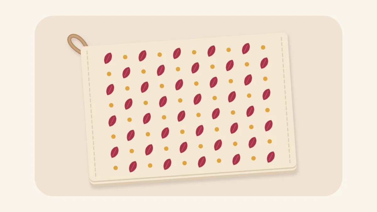Folded cream tea towel hand-stamped with berry leaves and honey dots