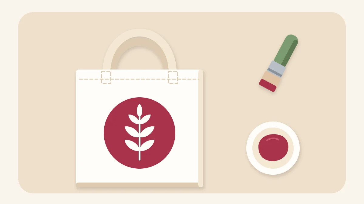 Cream canvas tote bag with a berry stenciled emblem, next to a stencil brush and paint
